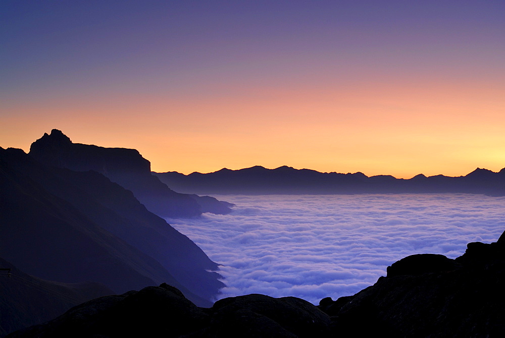 dawn above fog bank in valley Gschnitztal, Kirchdachspitze in background, Bremer Huette, Stubaier Alpen range, Stubai, Tyrol, Austria