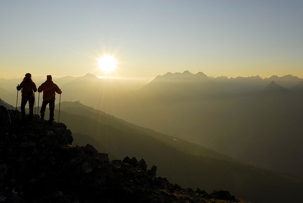 Two Hikers on Glanderspitze looking at Krahberg and Lechtaler Alpen range, Venet, Oetztaler Alpen range, Tyrol, Austria