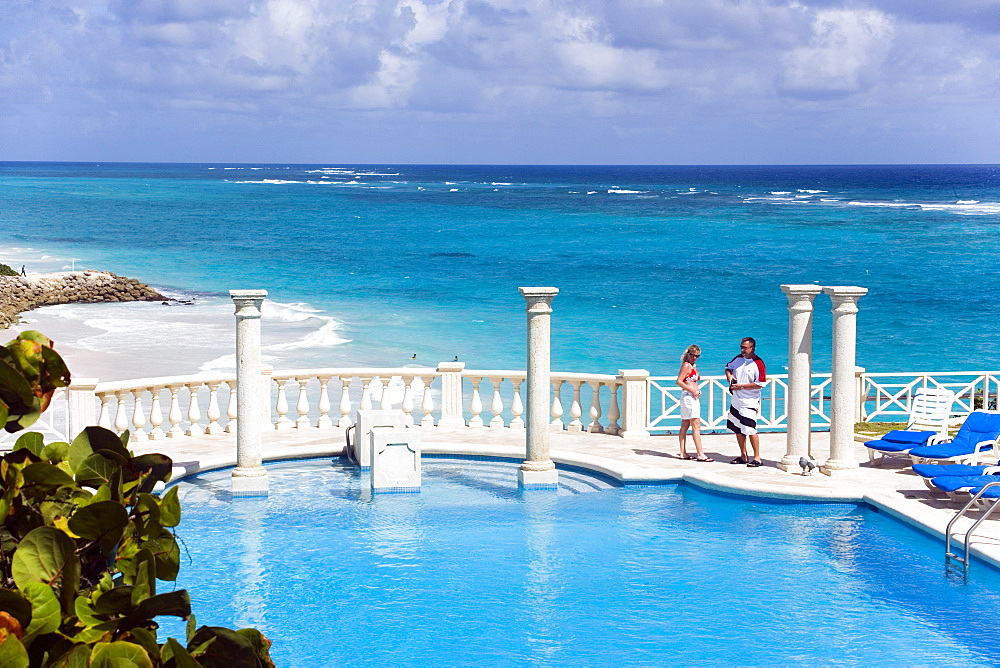 Vacationer at swimming pool of the Crane Hotel, Atlantic Ocean in background, Barbados, Caribbean