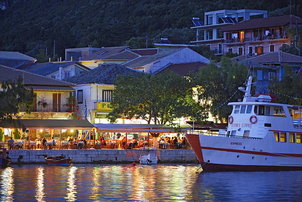 People sitting in a tavern at the harbour of Vasiliki in the evening, Lefkada, Ionische Inseln, Greece