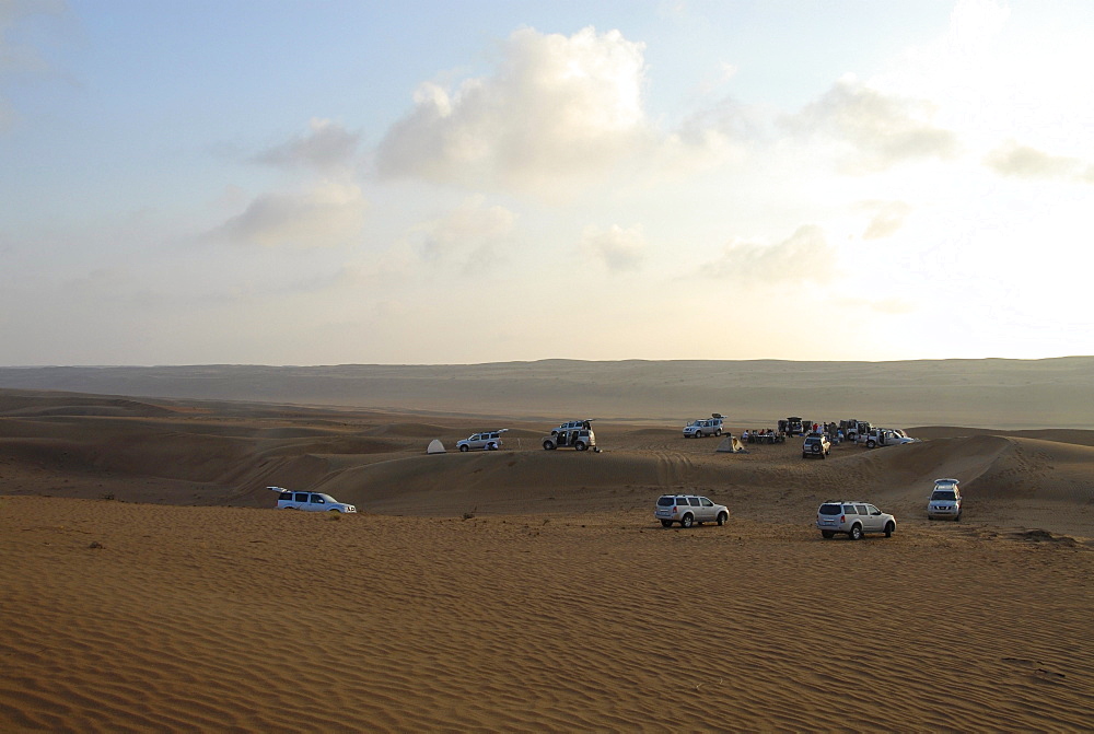 All-terrain vehicles standing in the sands of the desert at dawn, Wahiba Sands, Oman, Asia