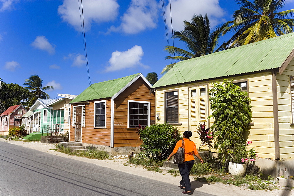 Woman walking along Chattel Houses, Six Men's Bay, Barbados, Caribbean