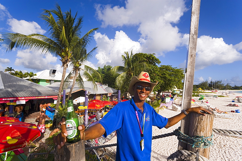 Man smiling at camera, the Boatyard beach bar in background, Bridgetown, Barbados, Caribbean