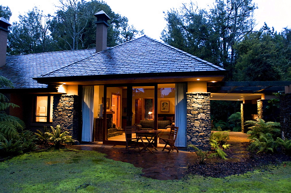 View at the illuminated windows at the Treetops Lodge in the evening, North Island, New Zealand, Oceania