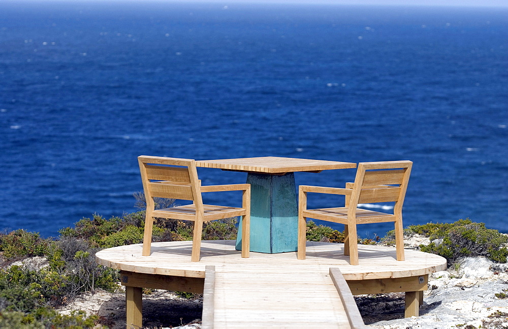 Chairs and a table on a terrace high above the ocean, Kangaroo Island, South Australia, Australia