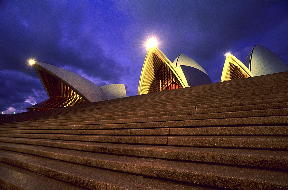 View at stairs in front of the illuminated Opera House in the evening, Sydney, New South Wales, Australia