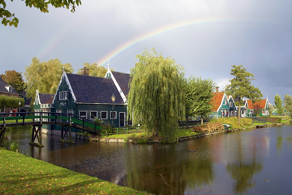 Houses at the river Zaan under a rainbow, Open-air museum Zaanseschans, Netherlands, Europe