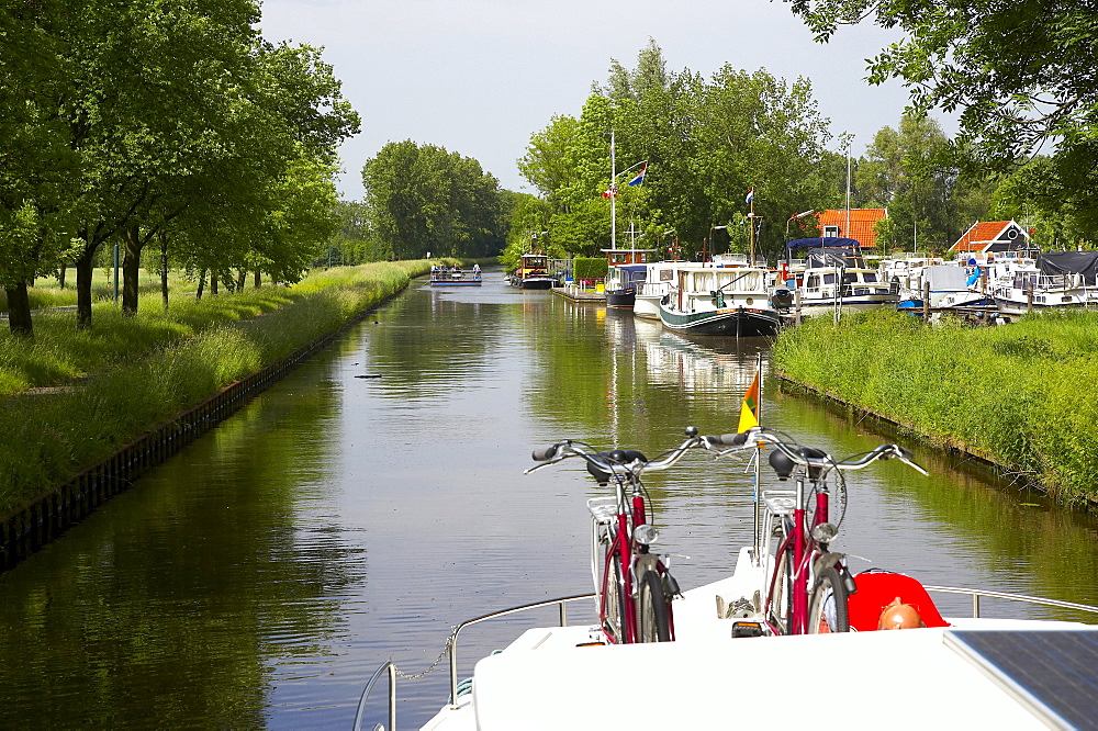 A man and two bicycles on a houseboat on the river Grecht, Netherlands, Europe