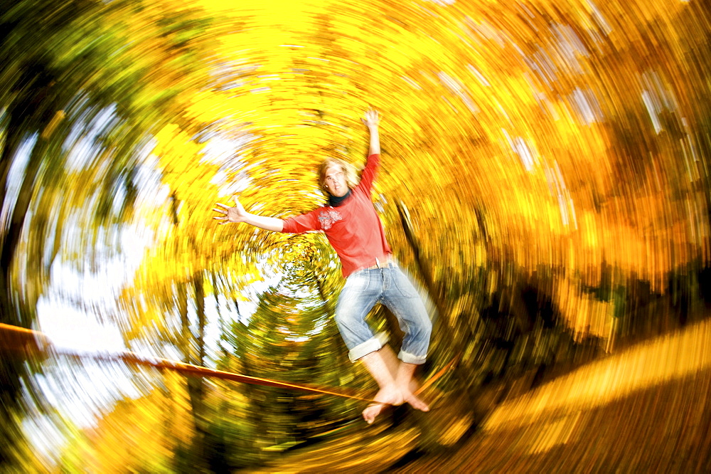 Young man balancing on a rope, slackline, Kaufbeuren, Bavaria, Germany