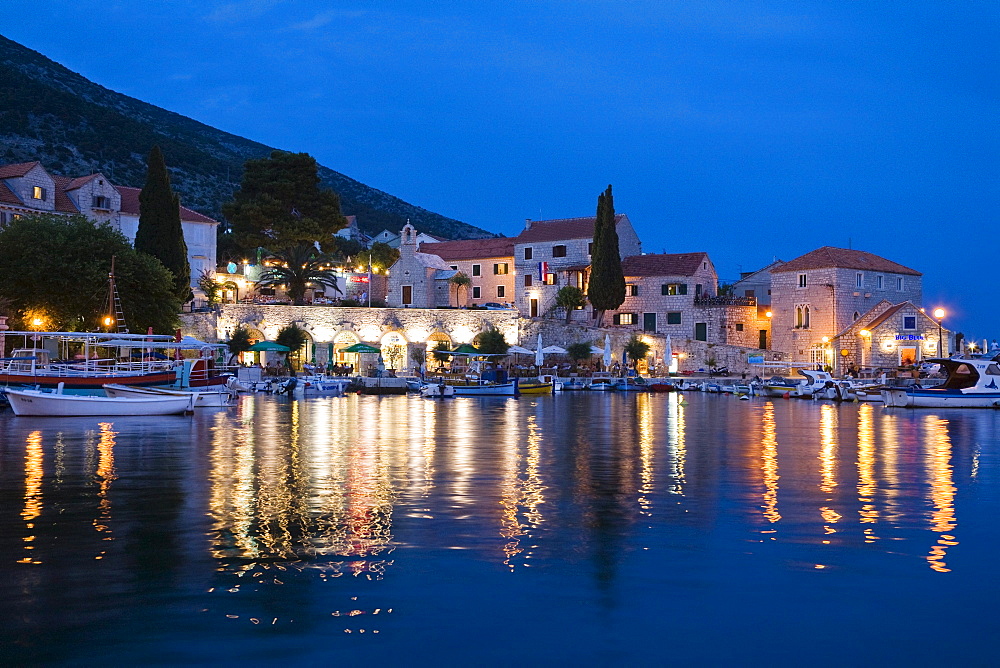 Illuminated houses at Bol harbour in the evening, Brac Island, Dalmatia, Croatia, Europe