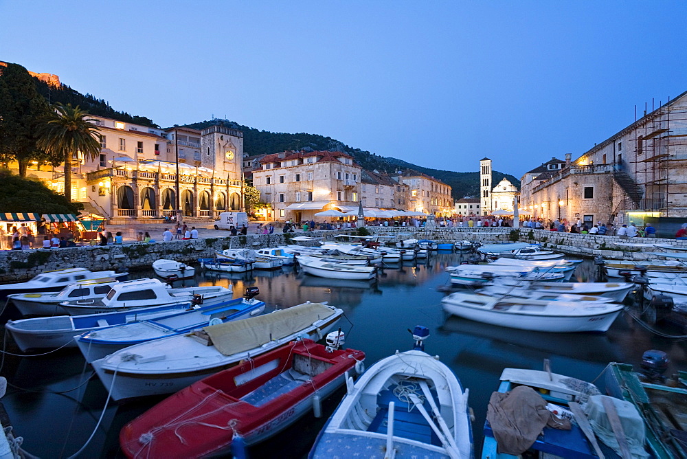 Boats at harbour and palace hotel at the Old Town in the evening, Hvar, Hvar Island, Dalmatia, Croatia, Europe