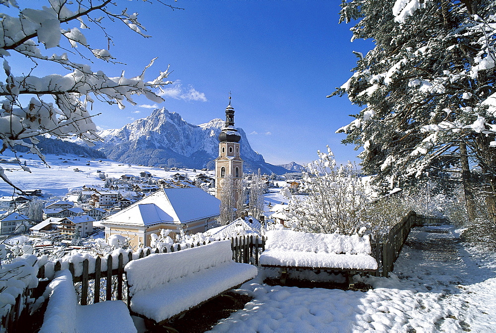 Snow covered houses and church under blue sky, Kastelruth, South Tyrol, Italy, Europe