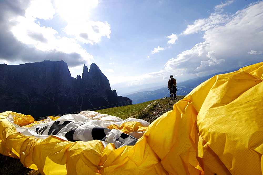 A person with paraglider standing in front of a slope, Alpe di Siusi, Valle Isarco, South Tyrol, Italy, Europe