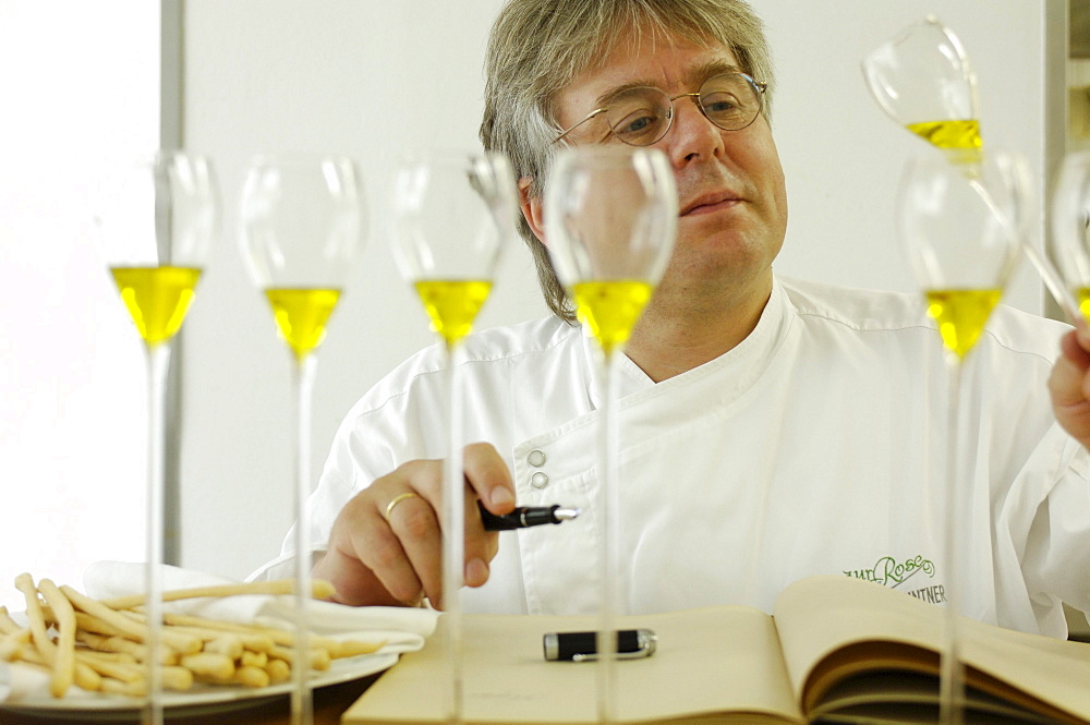 A cook tasting olive oil, Restaurant zur Rose, South Tyrol, Italy, Europe