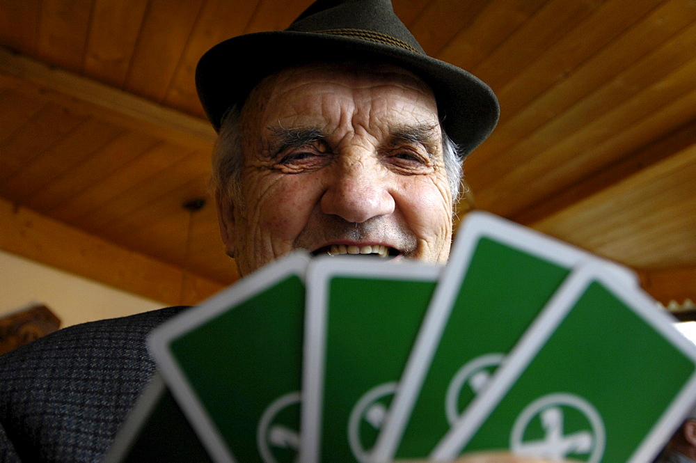 The face of an old man above playing cards, South Tyrol, Italy, Europe