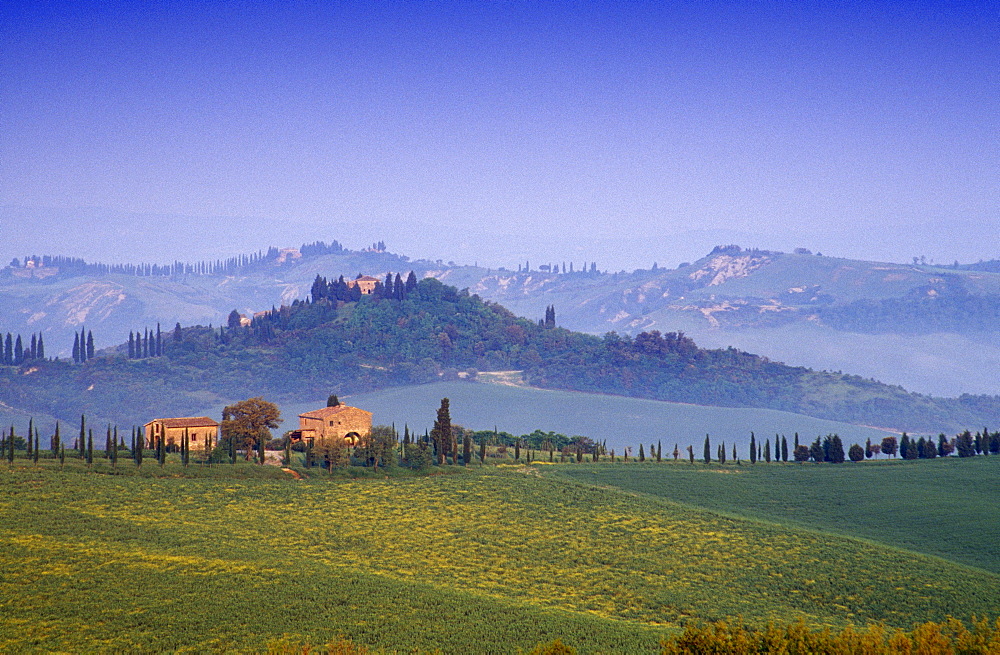 Hilly landscape with country houses under blue sky, Tuscany, Italy, Europe