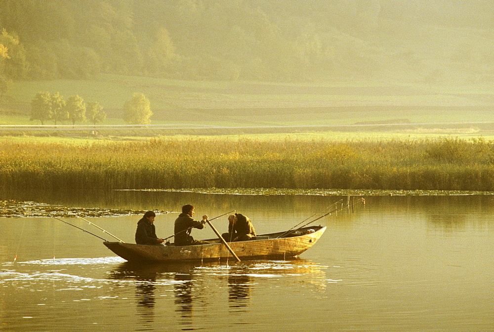 Angler in a boat on Meerfelder Maar, Eifel, Rhineland Palatinate, Germany