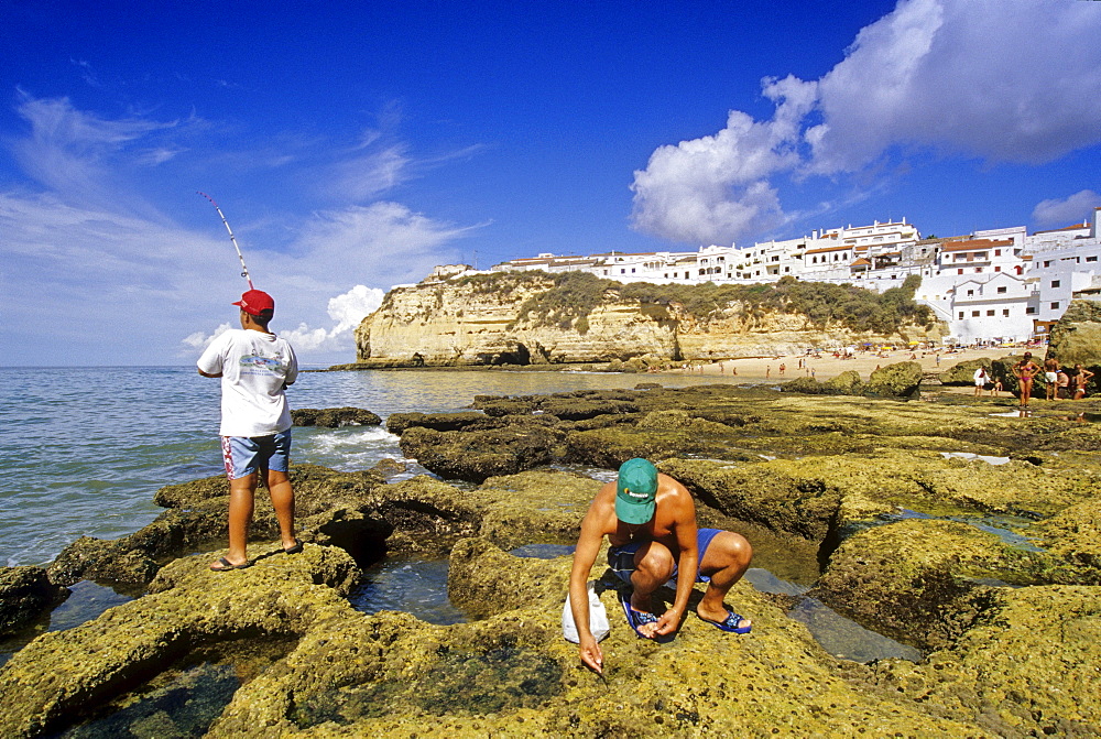 Angler and shell seaker on the beach under blue sky, Carvoeiro, Algarve, Portugal, Europe