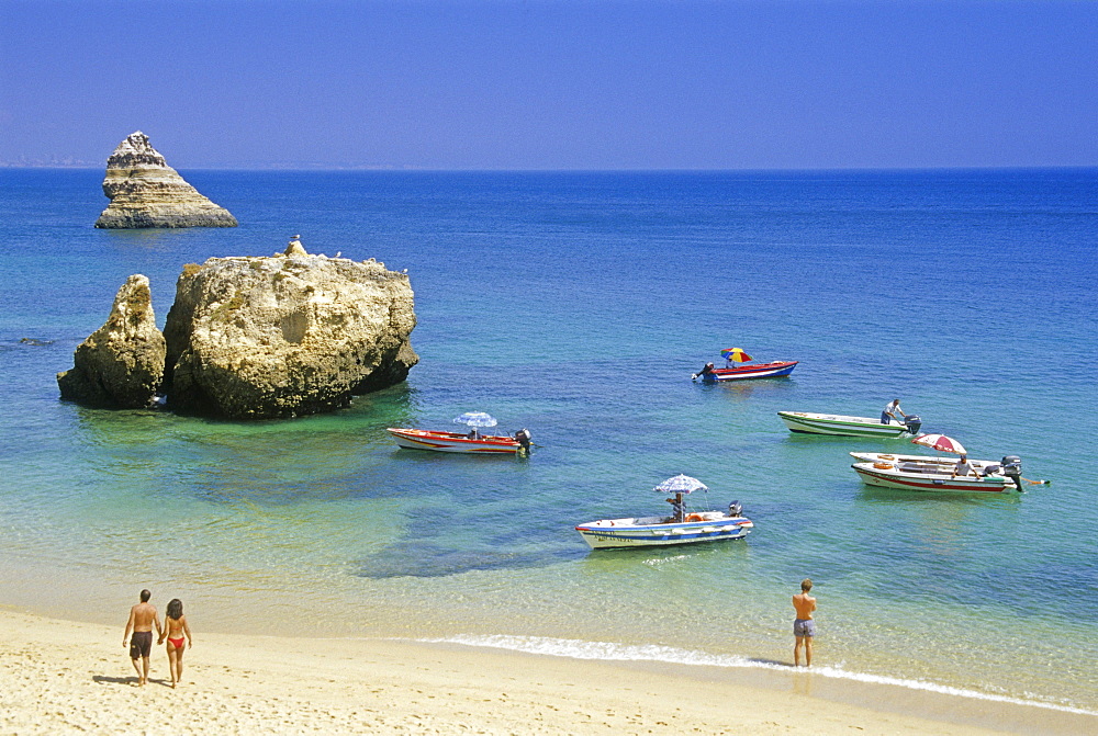 Excursion boats off the beach in the sunlight, Praia de Dona Ana, Algarve, Portugal, Europe