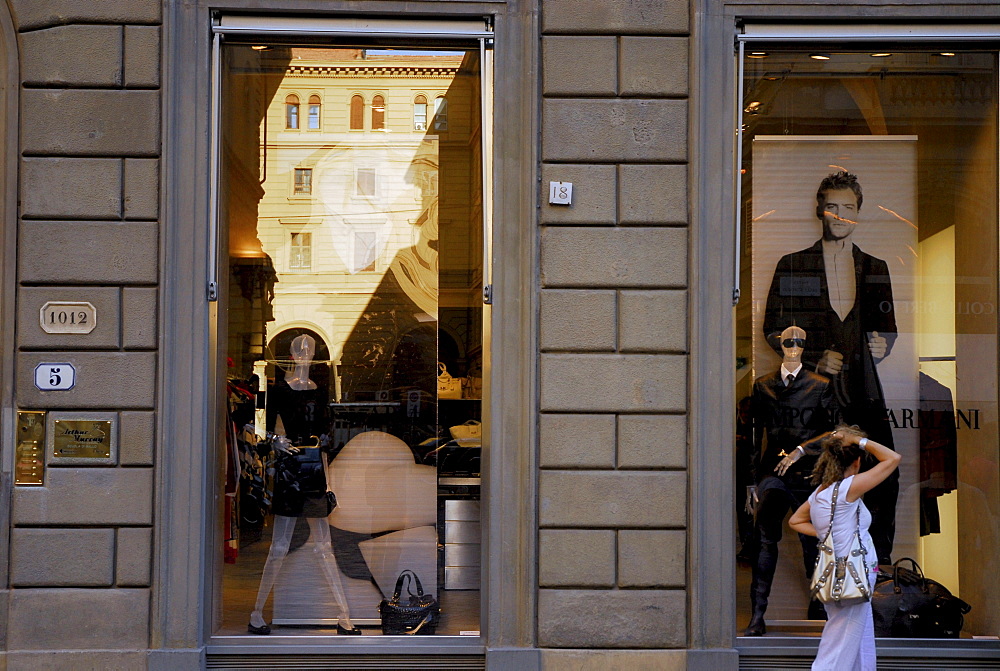 A woman in front of the shop window of the Designer Shop by Armani, Florence, Tuscany, Italy, Europe