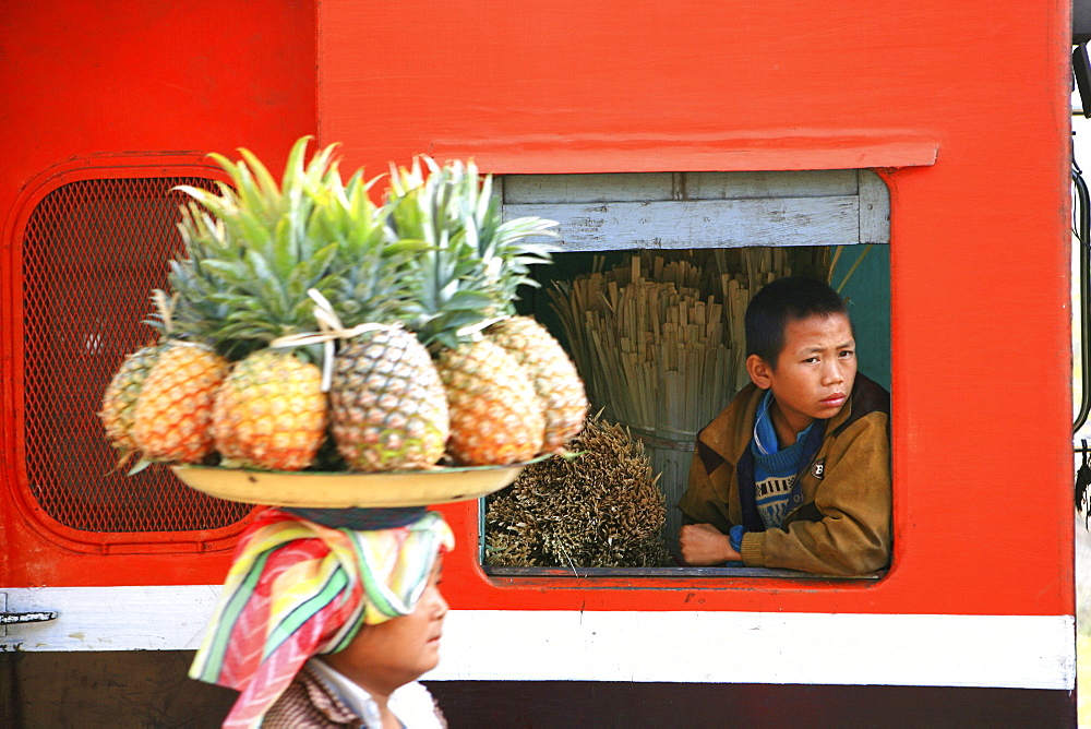 A woman selling fruit, a boy looking out of the window of a train, Hispaw, Shan State, Myanmar, Burma, Asia