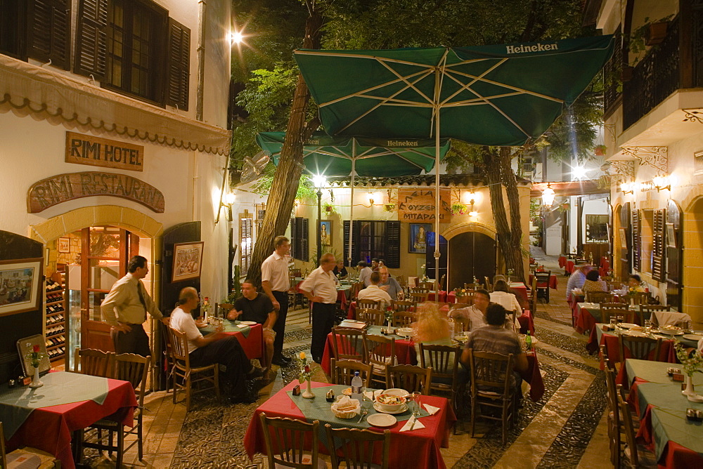 Life in the city, people sitting outside Rimi Restaurant at night enjoying an evening meal, Laiki Geitonia, Lefkosia, Nicosia, Cyprus