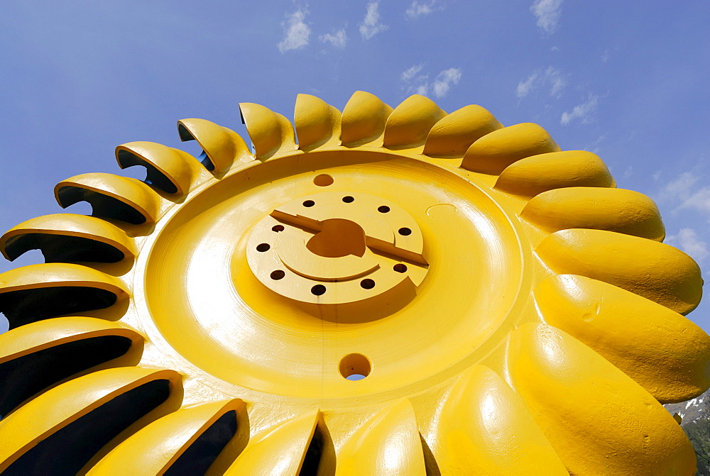 Yellow turbine wheel, Pelton turbine, water power plant near Loebbia, Bergell range, Grisons, Switzerland