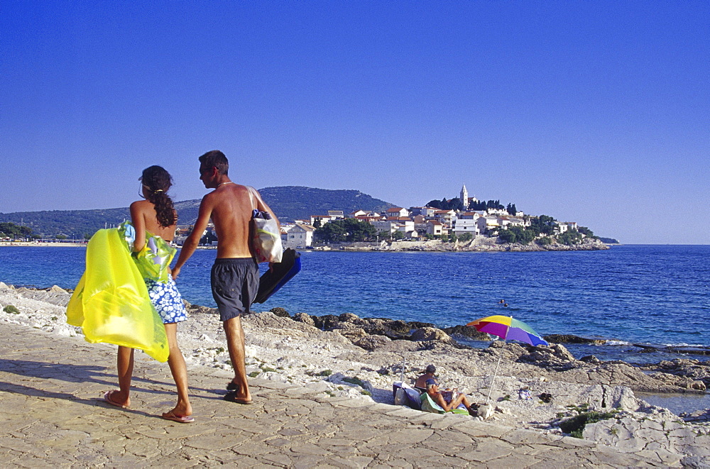 People on the seaside promenade under blue sky, Primosten, Croatian Adriatic Sea, Dalmatia, Croatia, Europe