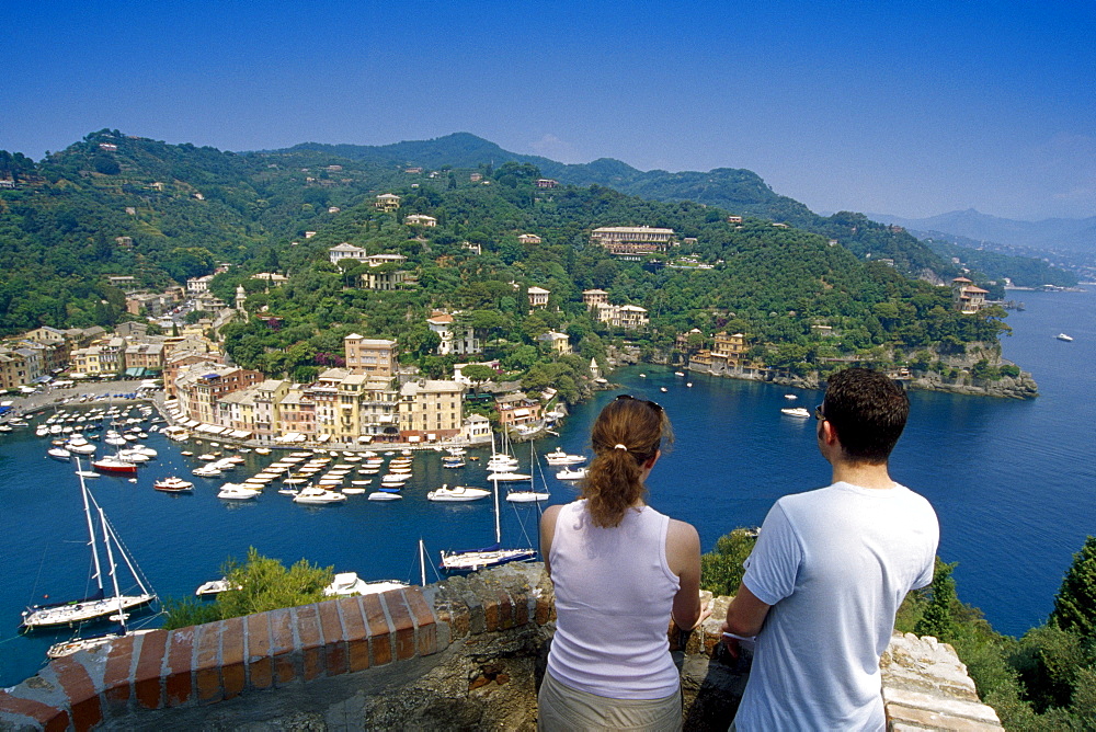 Young couple looking down at the marina, Portofino, Liguria, Italian Riviera, Italy, Europe