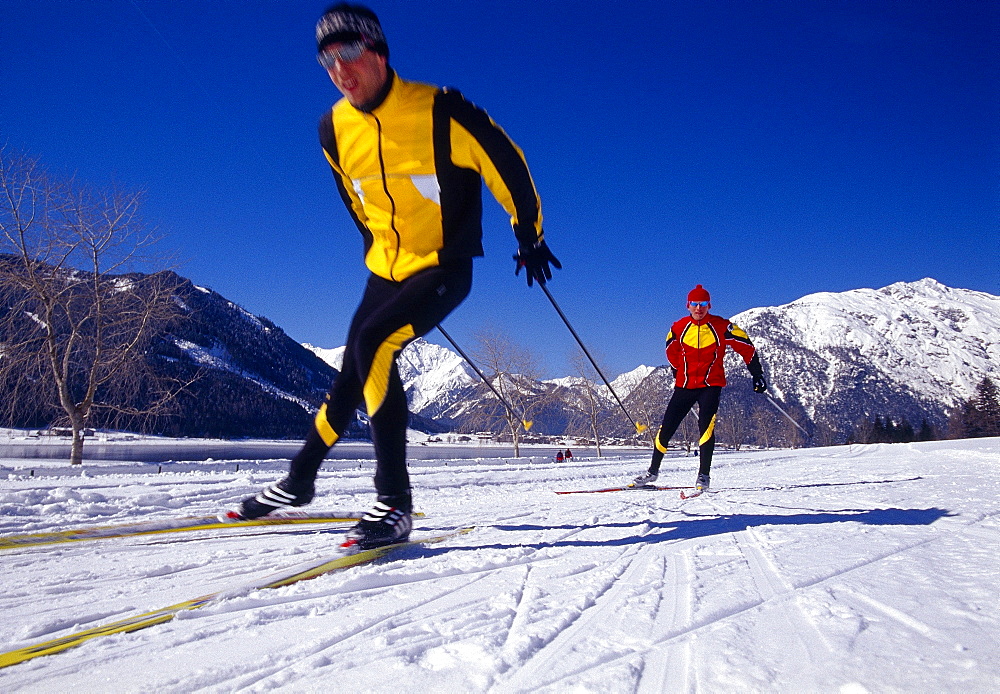 Two men cross-country skiing under blue sky, Tyrol, Austria, Europe