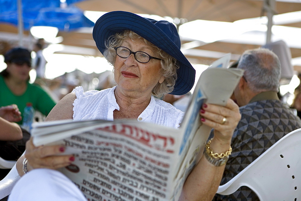 Old woman reading newspaper, Gordon Beach, Tel Aviv, Israel, Middle East