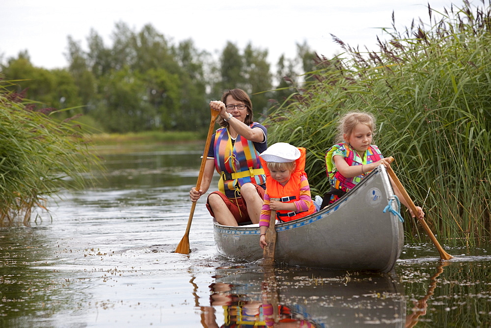 A woman and two girls in a canoe on the island of Norrbyskaer, Vaesterbotten, Sweden, Europe