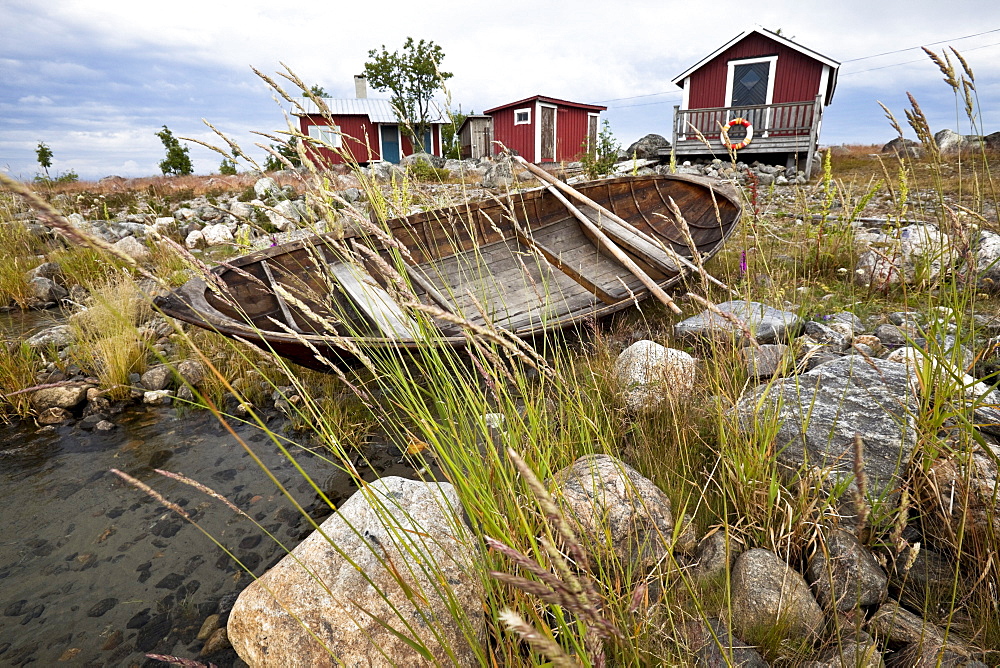 Cottages and rowing boat on the waterfront, island Stora Fjaederaegg, Vaesterbotten, Sweden, Europe