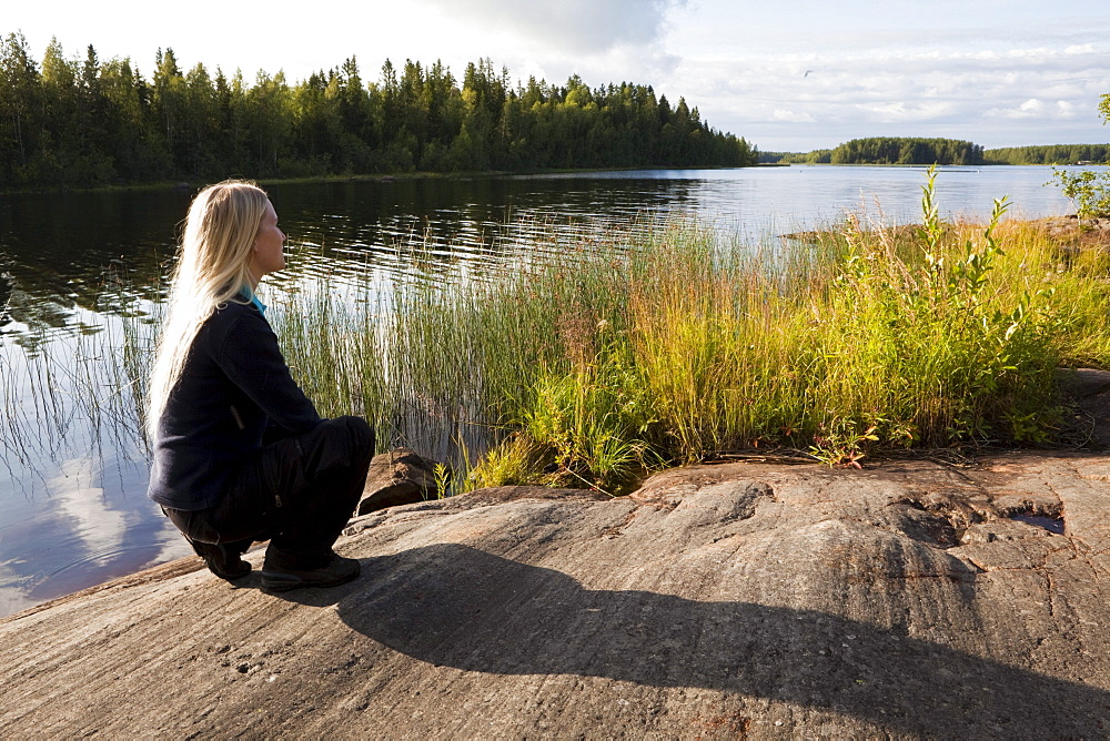 A woman looking over a lake, Vaesterbotten, Sweden, Europe