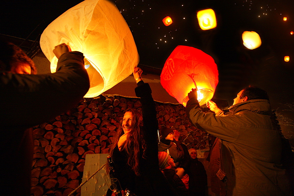 People lighting skylaterns on new year, Munsing, Bavaria, Germany