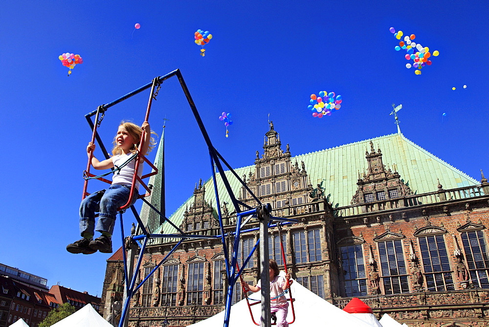 Girl on a swing at childrenÂ¥s party in front of the city hall at the market square, Hanseatic City of Bremen, Germany, Europe