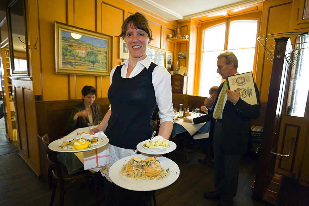 A waitress carrying traditional food, Restaurant Harmonie, Old City of Berne, Berne, Switzerland