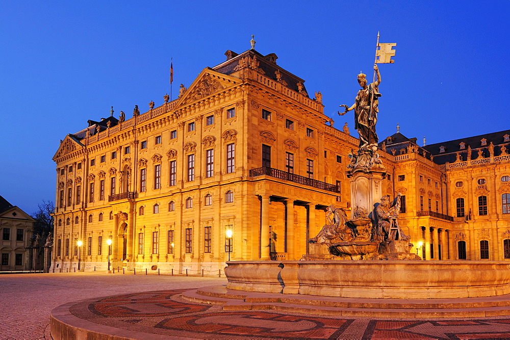 Illuminated fountain Frankoniabrunnen and Wuerzburger residence in the evening light, Wuerzburg, UNESCO World Heritage Site Wuerzburg, Bavaria, Germany