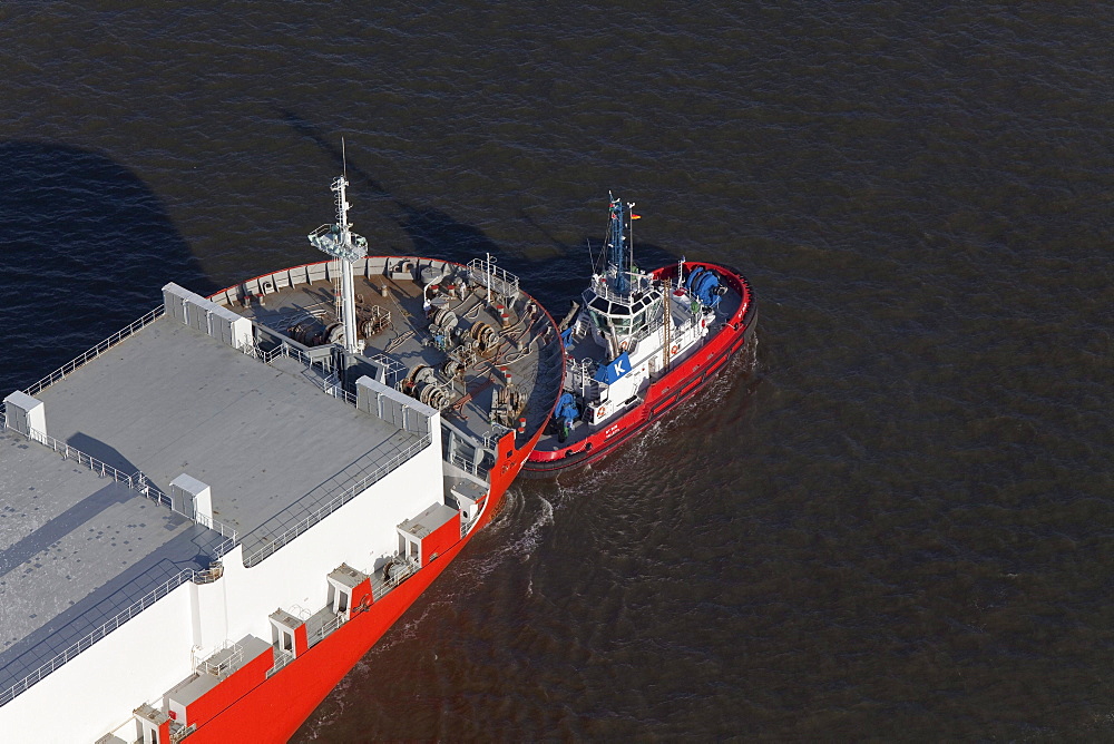 Aerial view of a freighter being towed into the harbour, Bremerhaven, northern Germany