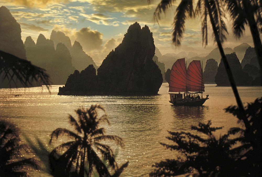 Junk in front of limestone formation at sunset, Halong Bay, Vietnam, Asia