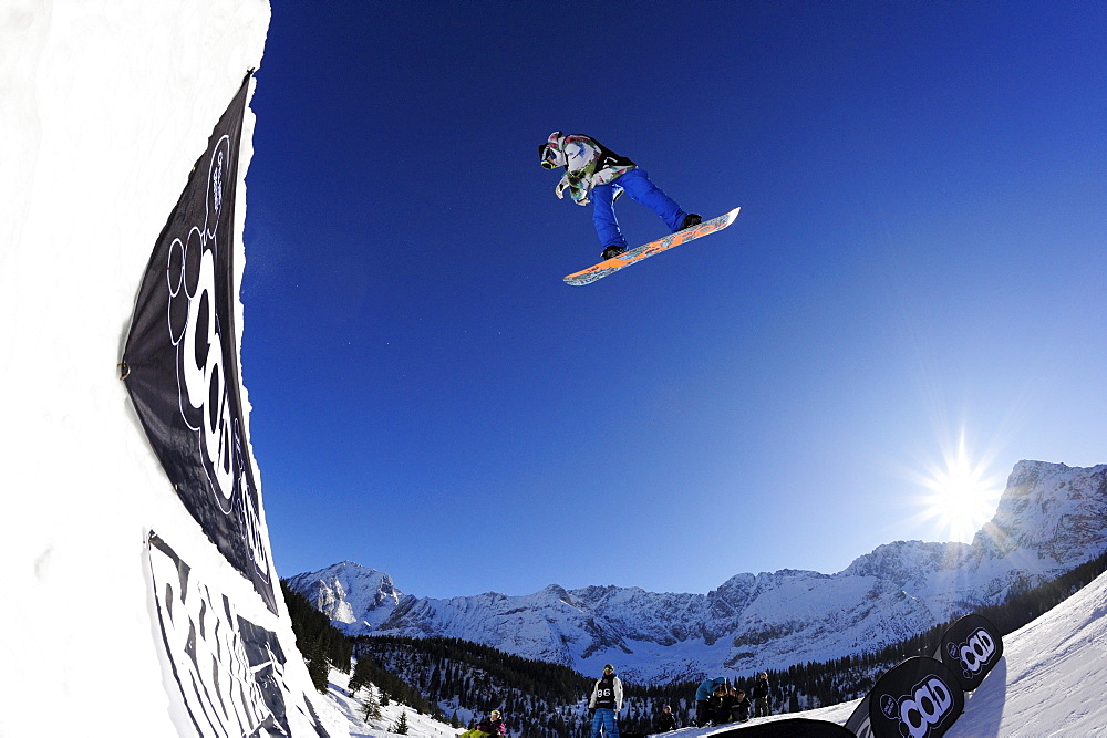 Snowboarder jumping from a kicker, performing a stunt, funpark Ehrwalder Alm, Tiroler Zugspitzarena, Ehrwald, Tyrol, Austria