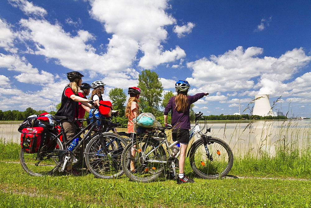 Cyclists looking over river Isar to Isar 1 Nuclear Power Plant, near Landshut, Isar Cycle Route, Lower Bavaria, Germany