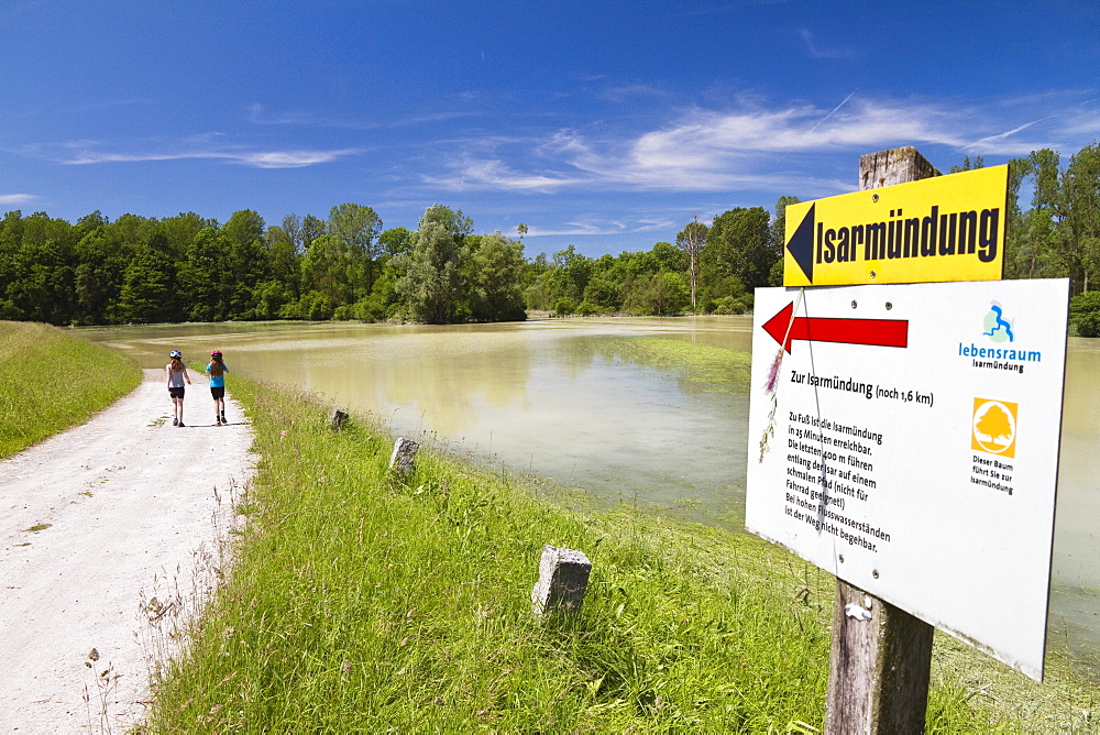 Two girls walking along Isar Cycle Route, Isarmuend, Lower Bavaria, Germany