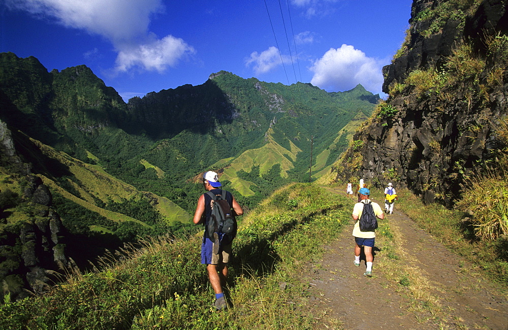 People hiking through the wild interior of the island of Fatu Iva, French Polynesia