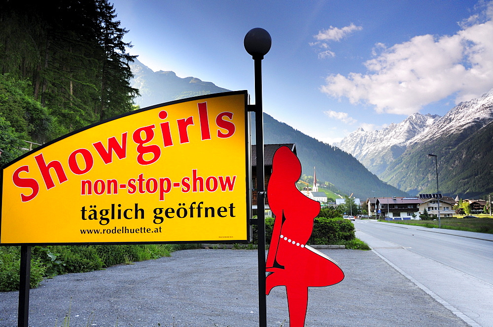 Illuminated advertising for a night show with village and mountains in the background, Soelden, Oetztal valley, Tyrol, Austria