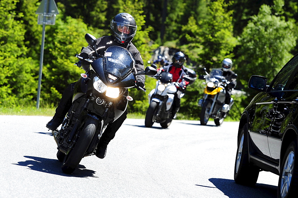 Group of biker driving past car, pass street, Kuehtai, Stubai range, South Tyrol, Italy