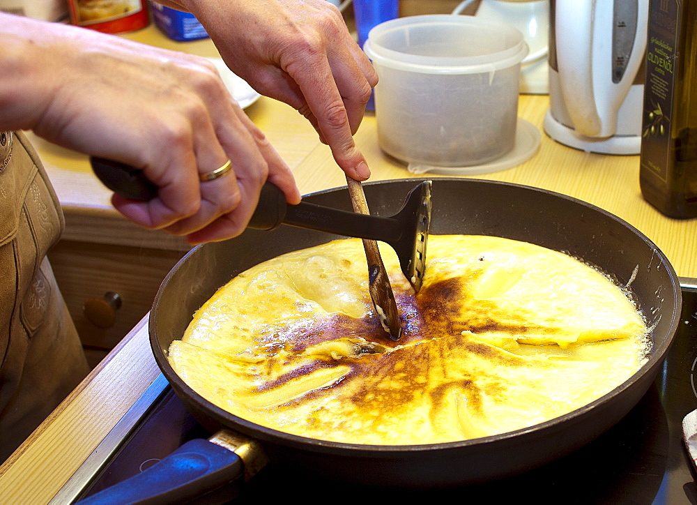 Cook cutting-up the sugared raisin pancake, Molterau alpine hut, Region of Hochkoenig, Salzburger Land, Austria