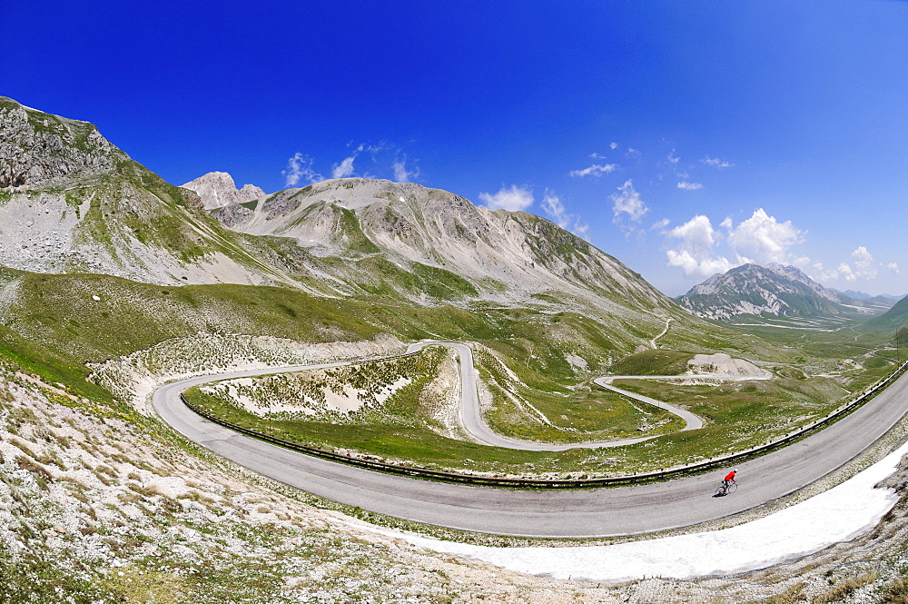 Cyclist on country road at Campo Imperatore, Gran Sasso National Park, Abruzzi, Italy, Europe