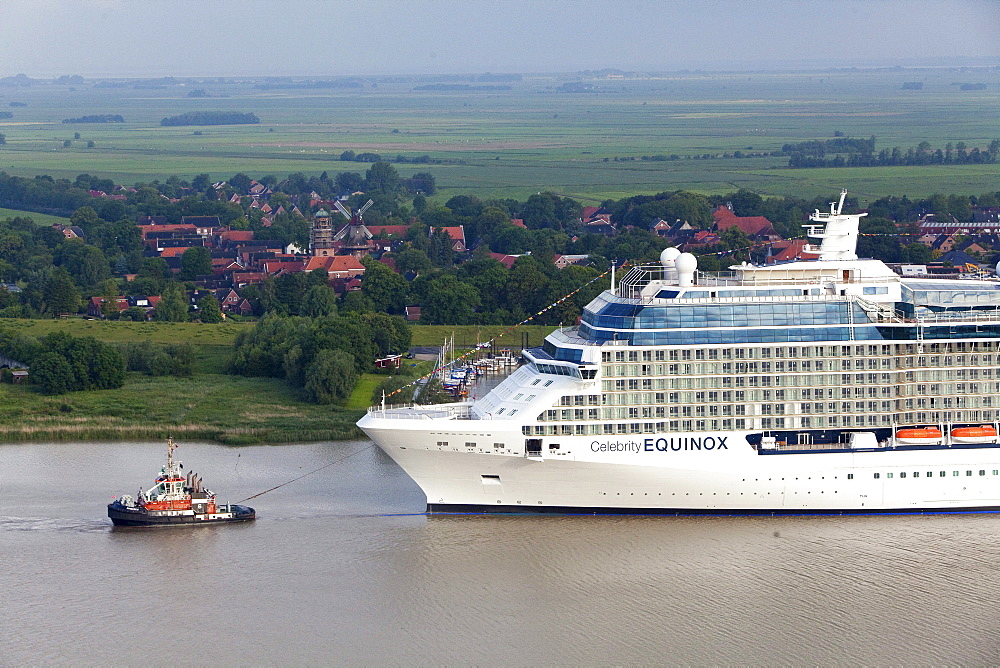 Tug boat navigating the newly launched Celebrity Equinox from the Meyer Werft along the River Ems, Lower Saxony, Germany