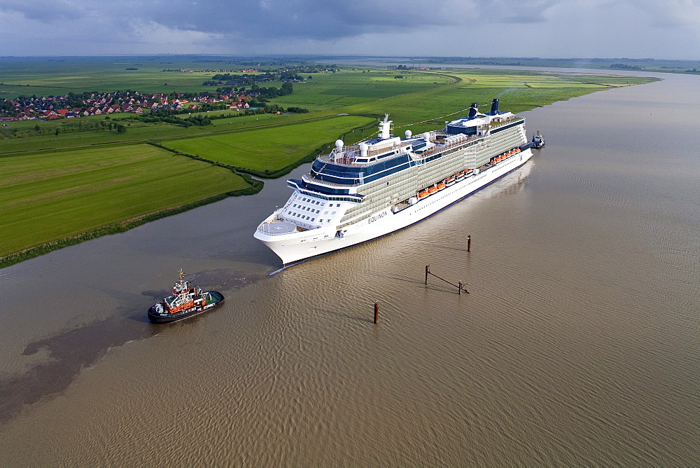 Tug boat navigating the newly launched Celebrity Equinox from the Meyer Werft along the River Ems, Lower Saxony, Germany